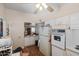 Bright kitchen featuring white appliances, wood-look floors, and a peek-through window to another room at 11038 W Windsor Dr, Sun City, AZ 85351