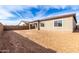 Large, empty backyard, perfect for customization, with block wall for privacy and views of the home's rear at 17617 W Blue Sky Dr, Surprise, AZ 85387