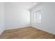 Clean bedroom design with a single window and wood-look tile flooring at 4780 W Flat Iron Ct, Queen Creek, AZ 85144
