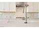Close-up of a kitchen faucet and sink, highlighting the marble countertops and backsplash details at 4780 W Flat Iron Ct, Queen Creek, AZ 85144