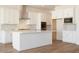 Bright kitchen boasts a large island, stainless steel appliances, and ample white cabinetry at 4780 W Flat Iron Ct, Queen Creek, AZ 85144