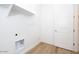 Functional laundry room with modern shelving, fixtures and wood-look tile flooring at 4780 W Flat Iron Ct, Queen Creek, AZ 85144