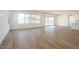 Open living space with wood-look tile flooring, large windows, and access to outdoor patio at 4780 W Flat Iron Ct, Queen Creek, AZ 85144