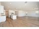 Spacious living room area with wood-look flooring and recessed lighting, connected to the kitchen at 4780 W Flat Iron Ct, Queen Creek, AZ 85144