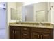 Bathroom vanity featuring double sinks, granite countertops, dark wood cabinets, and large mirrors at 846 N Pueblo Dr # 110, Casa Grande, AZ 85122