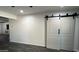 The living room has recessed lighting, a ceiling fan and modern barn doors at 4330 W Mescal St, Glendale, AZ 85304