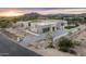 Expansive desert home showcases modern design with stone accents and stunning mountain views at sunset at 8386 E Leaning Rock Rd, Scottsdale, AZ 85266