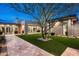 Backyard featuring a stone tile patio, turf grass, and desert landscaping at 8386 E Leaning Rock Rd, Scottsdale, AZ 85266