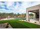 A modern home with manicured backyard featuring a pool, artificial turf and covered patio at 8386 E Leaning Rock Rd, Scottsdale, AZ 85266