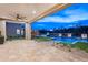 Luxury backyard with travertine patio, desert landscaping, modern pool, and stunning outdoor lighting at 8386 E Leaning Rock Rd, Scottsdale, AZ 85266