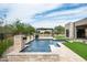 A modern home backyard with a pool, spa, travertine tile, artificial turf, and desert landscaping at 8386 E Leaning Rock Rd, Scottsdale, AZ 85266