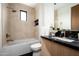 Stylish bathroom features tiled walls, black marble countertop, modern fixtures, and a soaking tub at 8386 E Leaning Rock Rd, Scottsdale, AZ 85266
