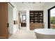 This modern bathroom features a soaking tub, wood cabinets with glass doors, and an open layout with neutral tones at 8386 E Leaning Rock Rd, Scottsdale, AZ 85266
