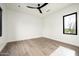An empty bedroom featuring hardwood floors, white walls, and a dark window frame overlooking the desert landscape at 8386 E Leaning Rock Rd, Scottsdale, AZ 85266