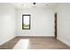 Bright, minimalist bedroom with wood floors, white walls, and a large window, providing ample natural light at 8386 E Leaning Rock Rd, Scottsdale, AZ 85266