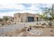 Striking contemporary home featuring stone accents, desert landscaping, and modern garage doors at 8386 E Leaning Rock Rd, Scottsdale, AZ 85266