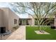 Stunning home exterior featuring a desert tree, travertine walkway, and manicured landscaping at 8386 E Leaning Rock Rd, Scottsdale, AZ 85266
