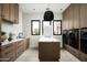 Functional laundry room with modern appliances, stylish lighting, and ample storage at 8386 E Leaning Rock Rd, Scottsdale, AZ 85266