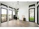 Bright living room with hardwood floors, white walls, designer light fixture, and windows overlooking the backyard at 8386 E Leaning Rock Rd, Scottsdale, AZ 85266