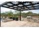 An outdoor kitchen with stone surround, stainless steel BBQ, and a pergola featuring a floral design at 8386 E Leaning Rock Rd, Scottsdale, AZ 85266