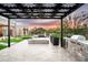 Beautiful outdoor kitchen with a floral pergola overlooking a pool and desert landscape at sunset at 8386 E Leaning Rock Rd, Scottsdale, AZ 85266