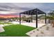 Outdoor kitchen with stone counters, floral pergola and lush landscaping make for elegant outdoor living at 8386 E Leaning Rock Rd, Scottsdale, AZ 85266