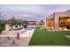 Beautiful pool area with spa, outdoor kitchen and dining area, and turf grass at 8386 E Leaning Rock Rd, Scottsdale, AZ 85266