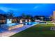 A luxurious pool and spa features a fire pit, lush artificial grass and travertine tile at 8386 E Leaning Rock Rd, Scottsdale, AZ 85266