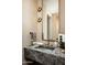 Stylish powder room with a marble sink and brushed gold fixtures at 8386 E Leaning Rock Rd, Scottsdale, AZ 85266
