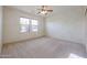 Bedroom with carpet flooring, ceiling fan, and large windows at 19403 N Ponderosa Ct, Surprise, AZ 85387