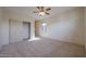 Bedroom with carpet flooring, ceiling fan, and walk-in closet at 19403 N Ponderosa Ct, Surprise, AZ 85387