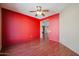 Bedroom with red accent wall and hardwood floors at 19403 N Ponderosa Ct, Surprise, AZ 85387