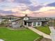 A community clubhouse featuring well-manicured landscaping, a covered patio, and an inviting entrance at 16033 W Hackamore Dr, Surprise, AZ 85387