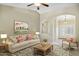 Bright living room with neutral tones, archway, ceiling fan, and comfortable furnishings at 15758 W Edgemont Ave, Goodyear, AZ 85395