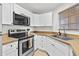 Charming kitchen featuring white cabinets, wood countertops, and modern appliances at 3845 E Greenway Rd # 131, Phoenix, AZ 85032