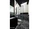 Modern bathroom with black and white finishes, unique tilework, and glass-enclosed shower at 6623 N Hillside Dr, Paradise Valley, AZ 85253