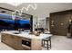 Contemporary kitchen featuring a waterfall island with seating, designer lighting, and a seamless transition to the living area at 6623 N Hillside Dr, Paradise Valley, AZ 85253