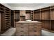 Spacious walk-in closet boasts custom wood cabinetry and a center island for ample storage at 6623 N Hillside Dr, Paradise Valley, AZ 85253