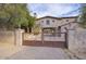 Gated entry to a stone house with paved driveway at 8000 E Mariposa Grande Dr, Scottsdale, AZ 85255
