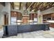 Gourmet kitchen with large island and wood beams at 8000 E Mariposa Grande Dr, Scottsdale, AZ 85255