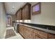 Laundry room with dark wood cabinets and granite countertops at 8000 E Mariposa Grande Dr, Scottsdale, AZ 85255