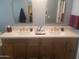 Bathroom with double sink vanity featuring quartz countertop and copper trimmed arch mirrors at 15626 N 50Th St, Scottsdale, AZ 85254