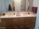 Bathroom featuring double sinks, quartz countertop, and copper trimmed arch mirrors at 15626 N 50Th St, Scottsdale, AZ 85254