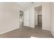 An empty bedroom featuring tile floors and three open doorways at 5678 N 205Th Ln, Buckeye, AZ 85396