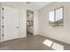 A light-filled bedroom with tile flooring and a view into an ensuite bathroom at 5678 N 205Th Ln, Buckeye, AZ 85396