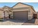 Contemporary-style home featuring a brick paver driveway, desert landscaping, and a spacious two-car garage at 5678 N 205Th Ln, Buckeye, AZ 85396