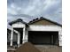 Exterior of home under construction shows open garage, covered porch and some roofing material at 5678 N 205Th Ln, Buckeye, AZ 85396