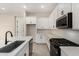 An airy kitchen featuring stainless steel appliances, white cabinets, quartz countertops, and tiled backsplash at 5678 N 205Th Ln, Buckeye, AZ 85396