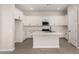 Bright kitchen with a center island, stainless steel appliances, and sleek, white cabinetry at 5678 N 205Th Ln, Buckeye, AZ 85396