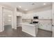 Bright kitchen with white cabinets, quartz countertops, island with sink, and stainless steel appliances at 5678 N 205Th Ln, Buckeye, AZ 85396